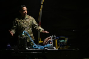 Master Sgt. Maynard Galvez, Pacific Air Forces Critical Care Transport Team senior enlisted leader, instructs medics on ventilator use in an En-Route Patient Staging Facility during a medical skills rodeo at Joint Base Pearl Harbor-Hickam, Hawaii, April 17, 2024. During the rodeo, Galvin instructed on the use of a ventilator, oral suctioning and collecting an upper respiratory specimen. (U.S. Air Force photo by Staff Sgt. Alan Ricker)