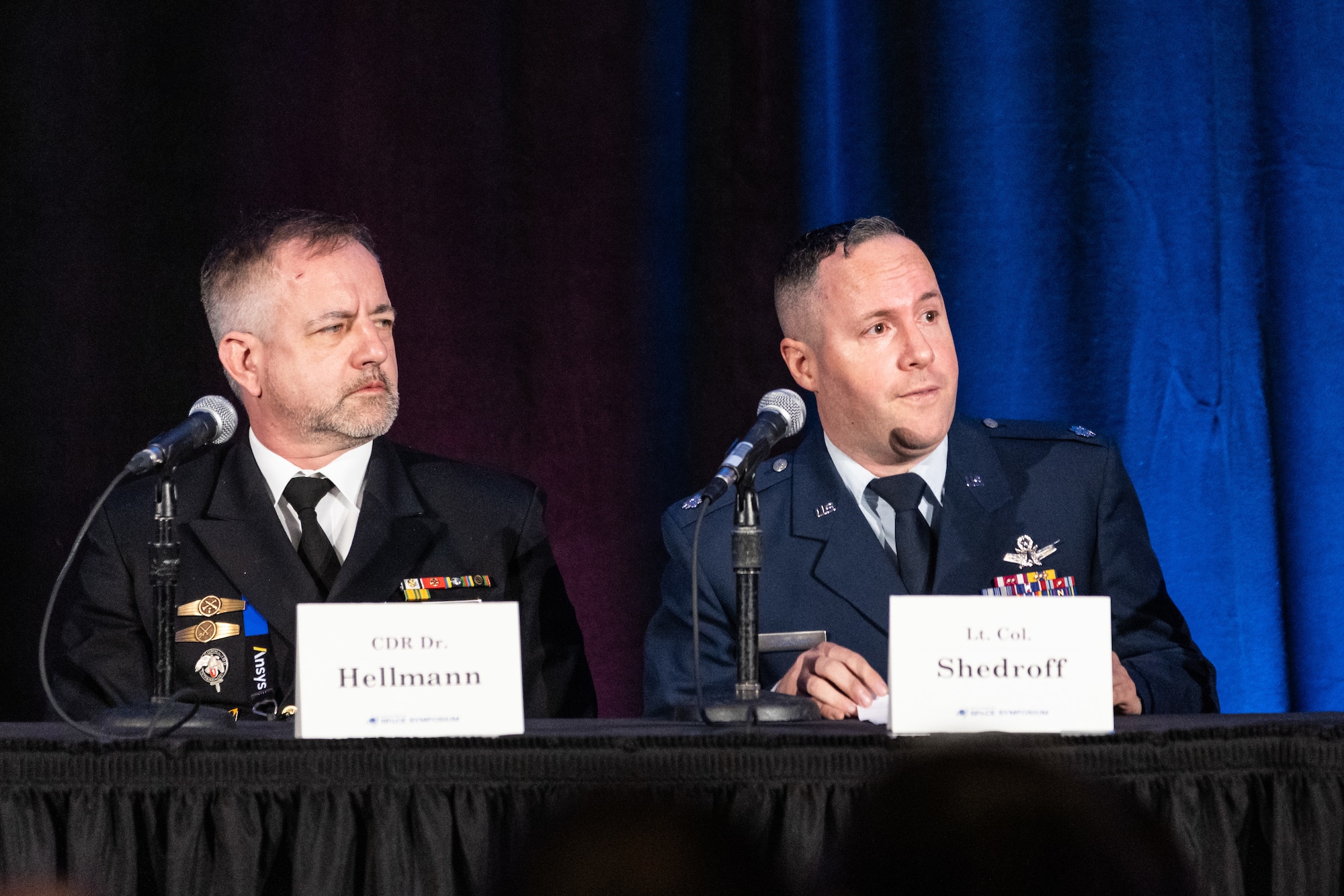 Two men in uniform speak on panel