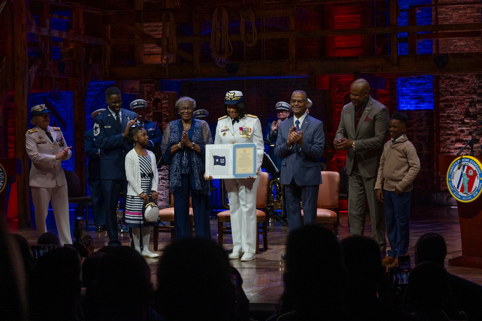 Capt. Zeita Merchant, the outgoing Coast Guard Sector New York commander, is shown with her family during a ceremony where she was frocked to the rank of rear admiral lower half at the Richard Rodgers Theatre in Manhattan, New York, April 22, 2024. Merchant is first African American woman to achieve this rank in the nearly 234-year history of the military service. (U.S. Coast Guard photo by Chief Warrant Officer Brandyn Hill)