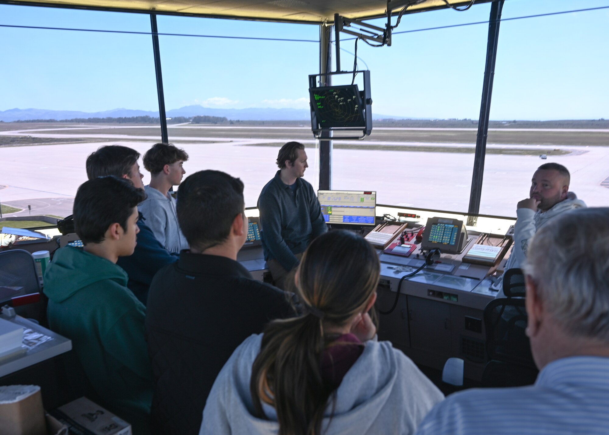 Man speaks to students inside air traffic control tower.