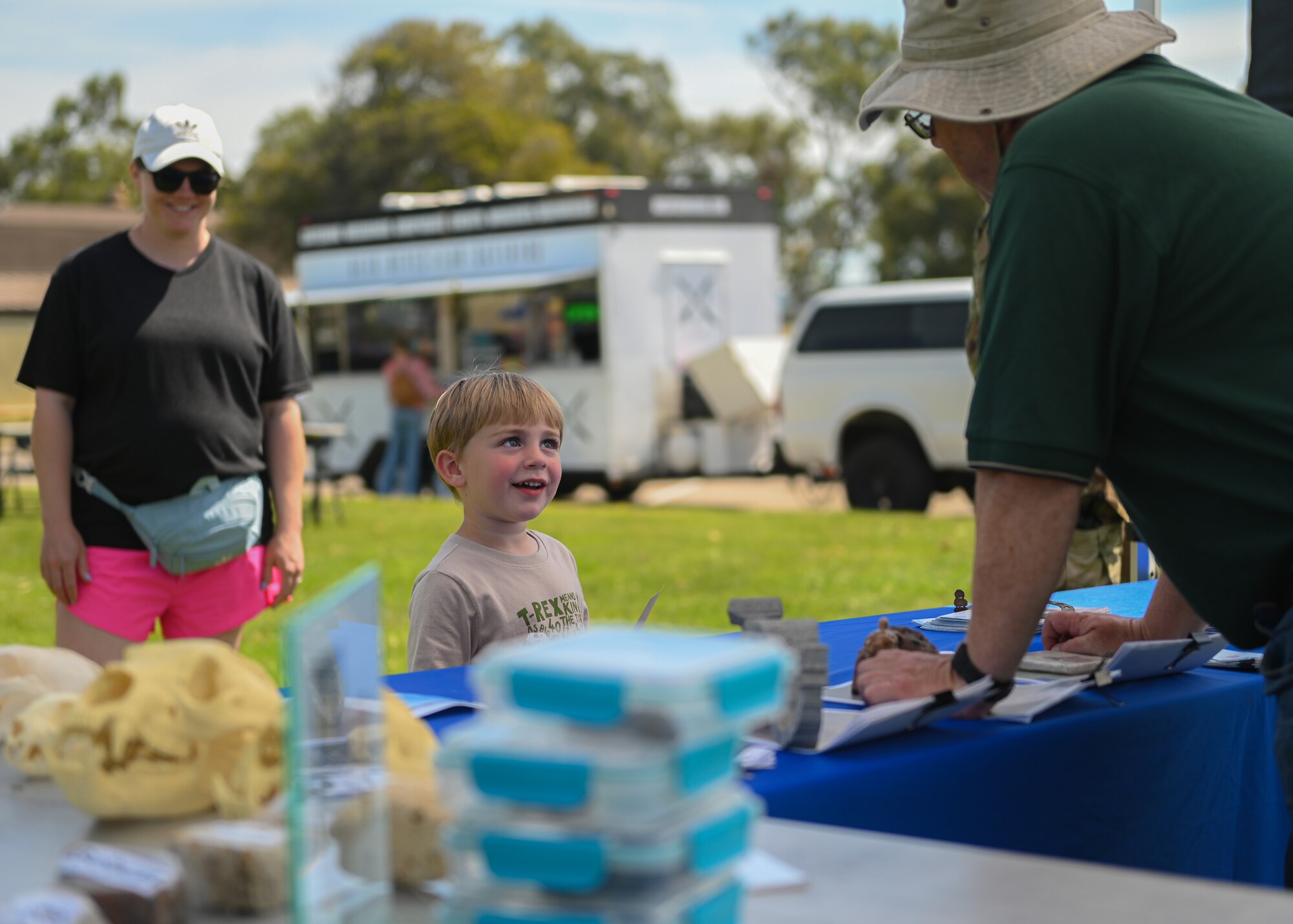 A child talks to a booth attendant at an outdoor exibit.