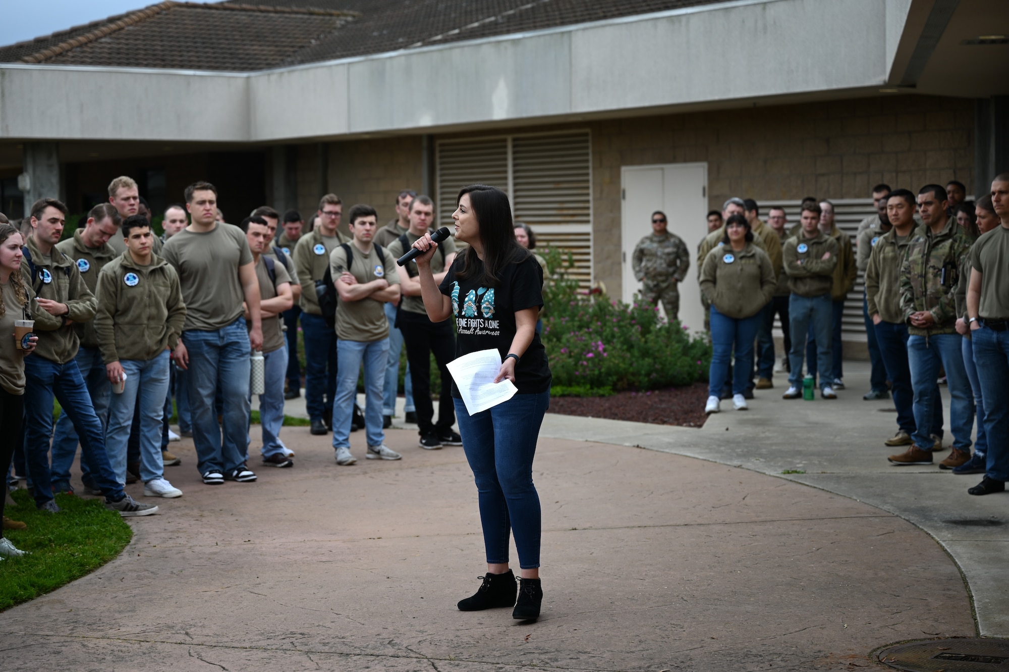 A women speaks into a microphone in front of a crowd of students.