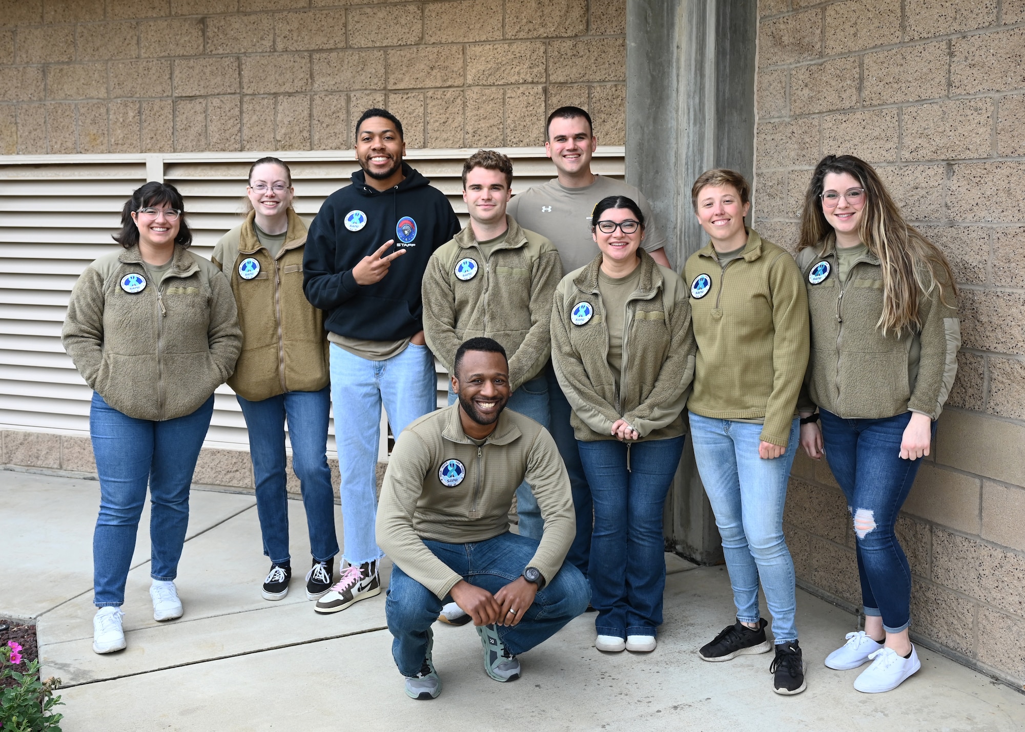 A group of people pose for a photo outside.