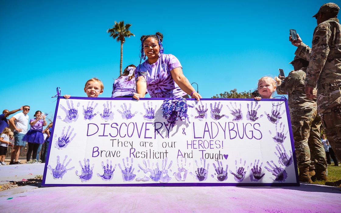 Children and caretakers from the Luke Air Force Base Child Development Center pose for a photo during a Purple Up parade.