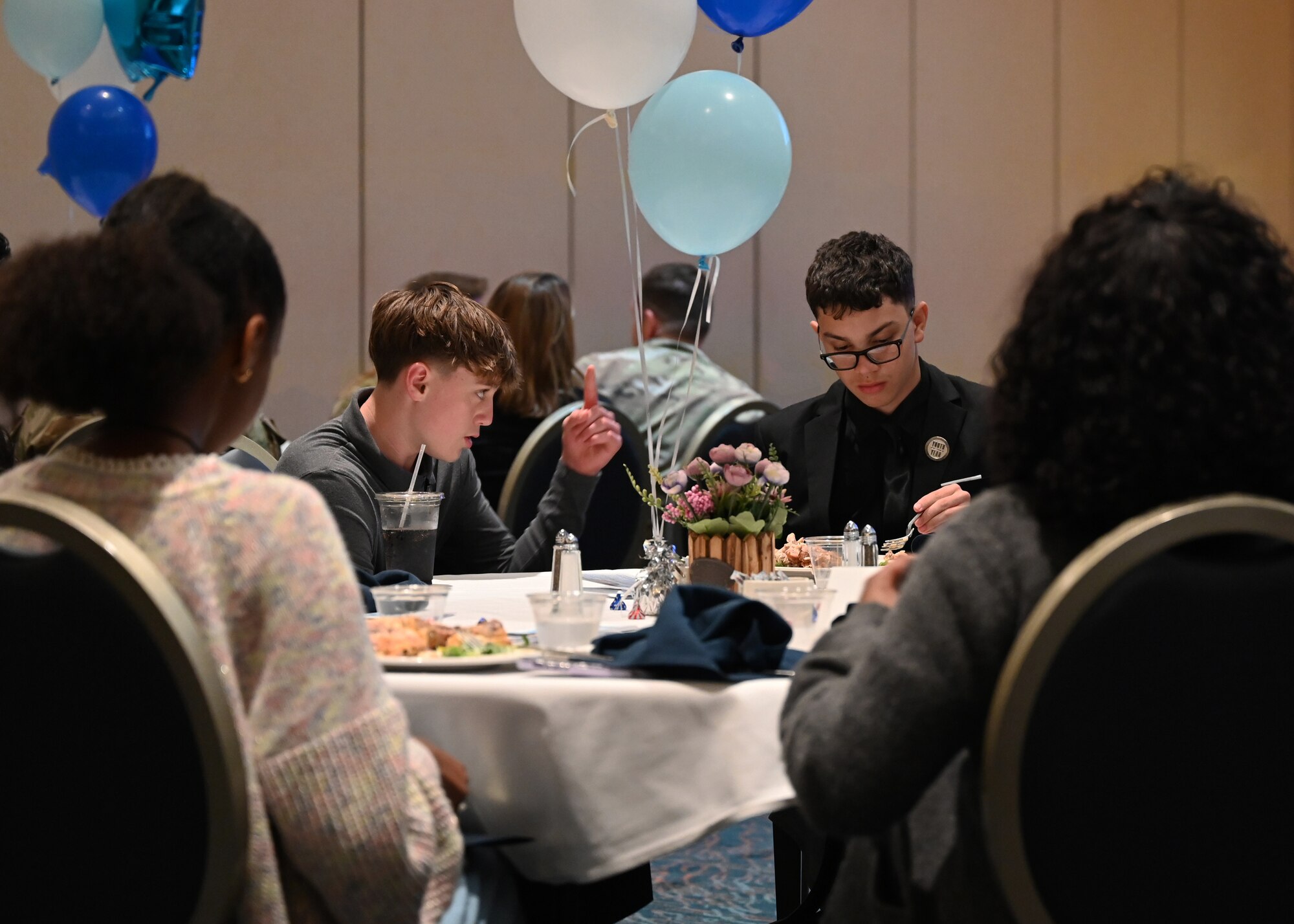 Children talk together at a table during dinner.