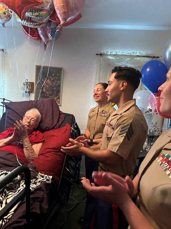 U.S. Marines with Headquarters Company, 23rd Marine Regiment, 4th Marine Division, clap with retired U.S. Marine Corps Corporal Lou 'Mama Lou' Keller as she thanks everyone for visiting her on her 99th Birthday, March 30, 2024 in San Jose, CA. Mama Lou served honorably at the Pentagon during the height of WWII.