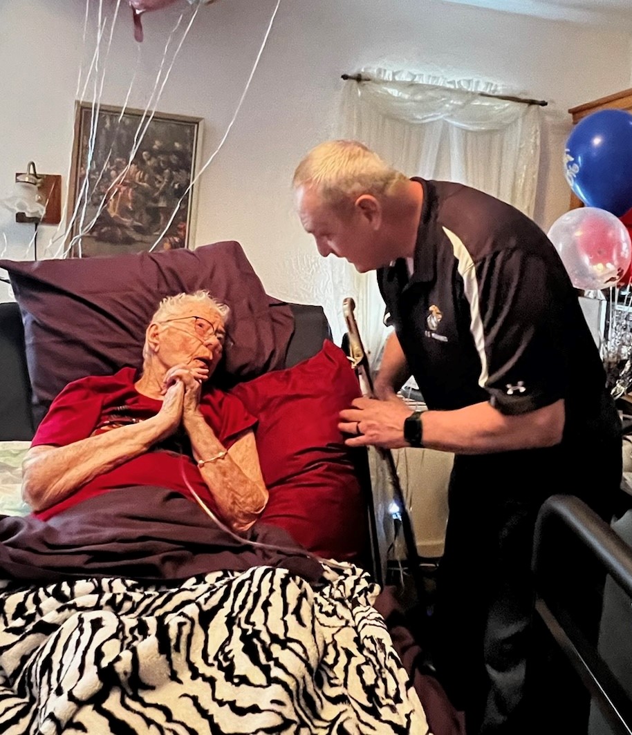 Mr. James Brown with Wine Country Marines talks with retired U.S. Marine Corps Corporal Lou 'Mama Lou' Keller about how thankful he is of her generation in the Marine Corps on her 99th Birthday celebration, March 30, 2024, in San Jose, CA. Mama Lou served in the Marine Corps during WWII and strives to continue to encourage the next generation of Marines.