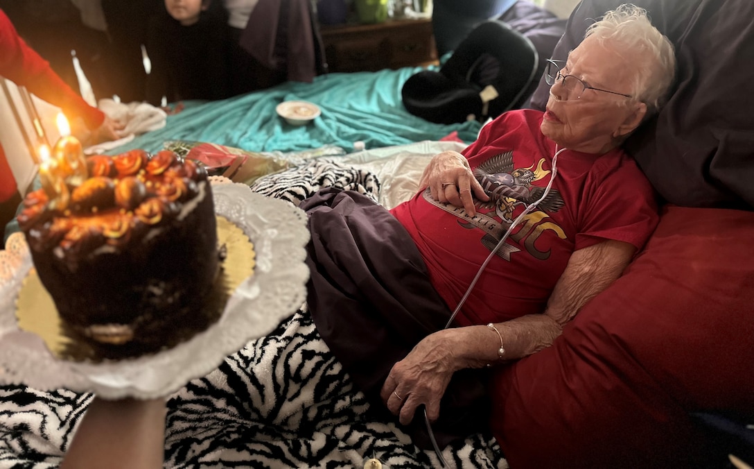 Retired U.S. Marine Corps Corporal Ruth 'Mama Lou' Keller receives her birthday cake during her 99th birthday celebration, March 30, 2024, in San Jose, CA. Mama Lou was stationed at the Pentagon during the height of WWII processing Purple Hearts.