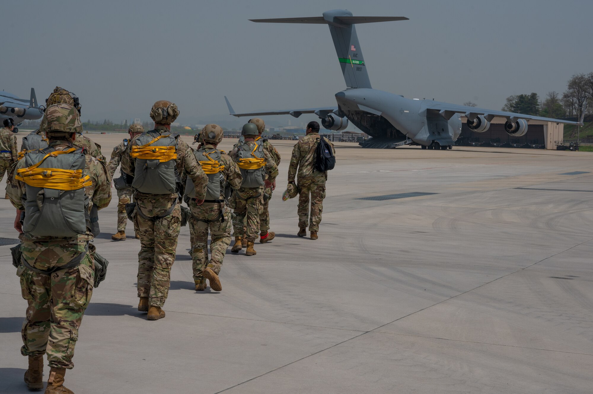 U.S. Special Operations Command Korea personnel approach a U.S. Air Force C-17 Globemaster III during Korea Flight Training 24 at Osan Air Base, Republic of Korea, April 18, 2024. KFT 24 is a routine annual training that prioritizes combat preparation through the tactical planning and rehearsal of combat capabilities. This training event included nearly 200 U.S. and ROK service members in a combined effort to maintain preparation and strengthen the U.S.-ROK alliance. (U.S. Air Force photo by Airman 1st Class Chase Verzaal) (This photo has been altered for security purposes.)