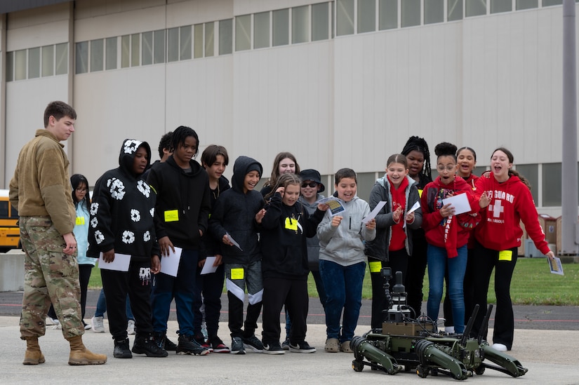 Students admire a robot dog during the Student Engagement and Career Day event at Joint Base McGuire-Dix-Lakehurst, N.J., April 19, 2024. The event is meant to inspire and motivate the next generation of future service members through a positive and lasting impact. (U.S. Air Force photo by Airman 1st Class Aidan Thompson)