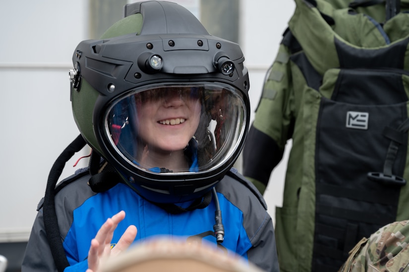A student tries on an explosive ordnance disposal helmet during the Student Engagement and Career Day event at Joint Base McGuire-Dix-Lakehurst, N.J., April 19, 2024. The event is meant to inspire and motivate the next generation of future service members through a positive and lasting impact. (U.S. Air Force photo by Airman 1st Class Aidan Thompson)