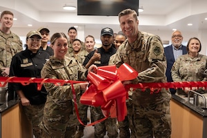 U.S. Air Force Col. Ryan Garlow, right, 100th Air Refueling Wing commander, and Master Sgt. Michaela Boles, left, 100th Force Support Squadron dining facility manager, cut the ribbon during the Gateway Dining Facility ribbon cutting ceremony at Royal Air Force Mildenhall, England, April 22, 2024.