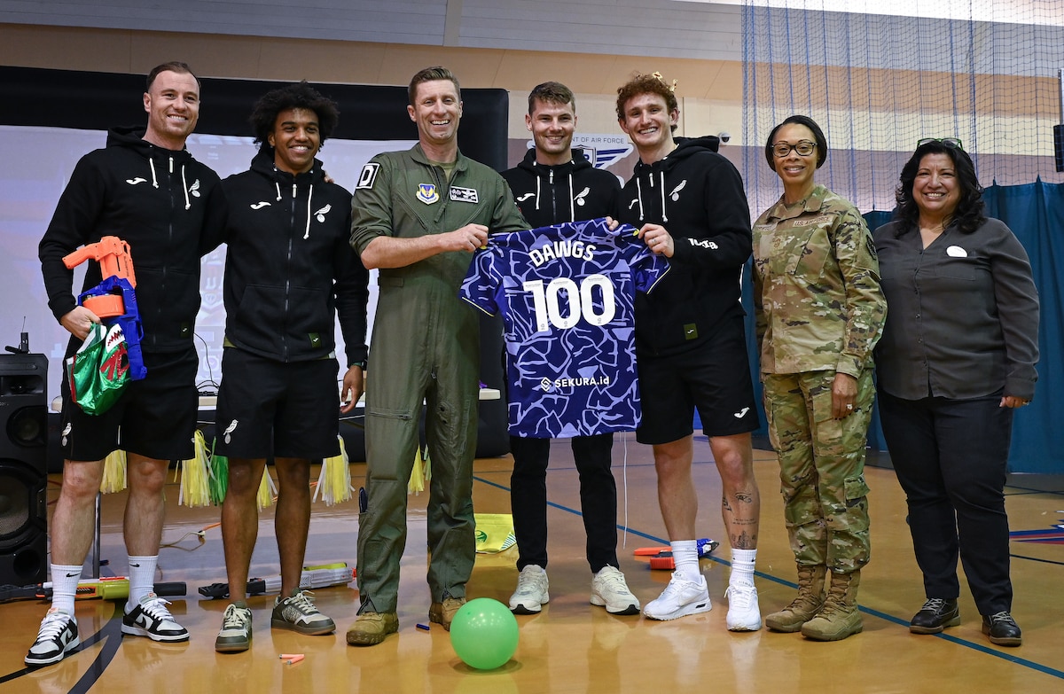 Team Mildenhall and Norwich City Football Club players unveil a purple jersey, representing the Month of the Military Child and the 100th Air Refueling Wing at Royal Air Force Mildenhall, England, April 17, 2024.