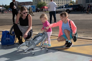 Lenka Kucera and her daughters enjoy an interactive robotic dog demonstration during the Science Technology Engineering and Mathematics (STEM) expo during the 2024 Beyond the Horizon Air and Space Show at Maxwell Air Force Base, Ala.,