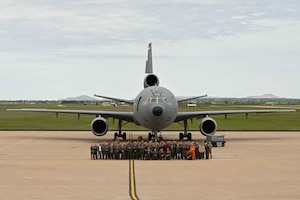 U.S. Air Force boom operators gather together for a picture in front of a KC-10 Extender aircraft during the 44th annual Boom Operator Symposium at Altus Air Force Base, Oklahoma, April 19, 2024. More than 100 active duty, guard, reserve, and retired boom operators attended the symposium. (U.S. Air Force photo by Airman 1st Class Kari Degraffenreed)