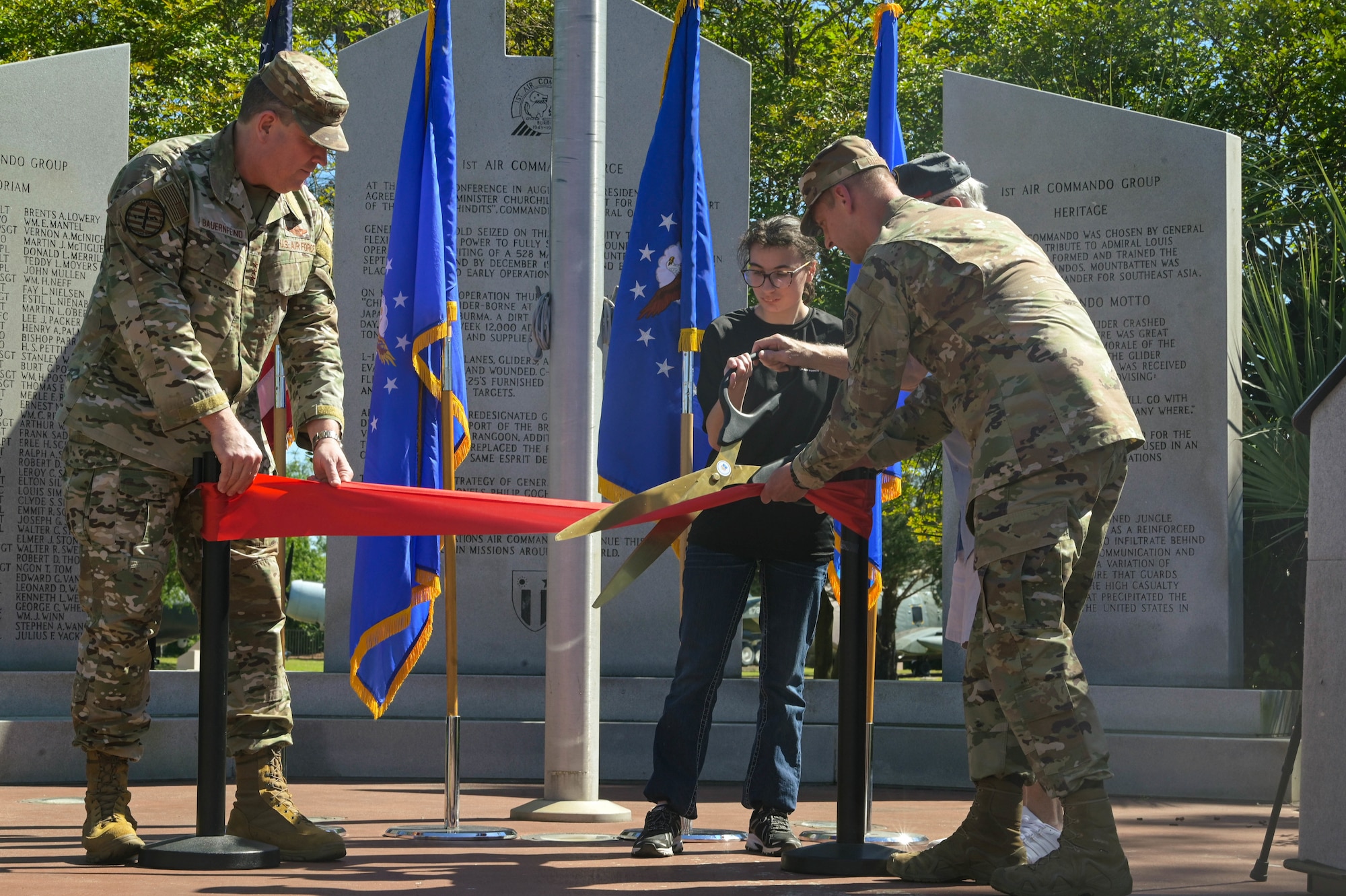 U.S. Air Force Lt. Gen. Tony Bauernfeind, Air Force Special Operations Command Commander, left, and Col. Patrick Dierig, 1st Special Operations Wing commander, right, cut the ribbon with Lt. Gen. Bruce Fister, former AFSOC commander and a Delayed Entry Program recruit during the grand reopening of the memorial air park at Hurlburt Field, Florida, April 22, 2024.