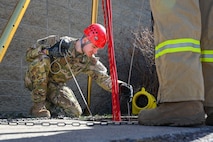 A person snakes a tube in a manhole