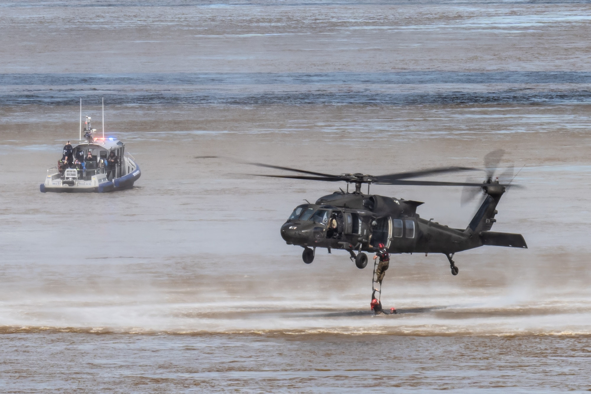 A pararescueman from the Kentucky Air National Guard’s 123rd Special Tactics Squadron executes a rope-ladder climb into a Kentucky Army National Guard UH-60 Black Hawk as part of a helocast water-rescue demonstration during the Thunder Over Louisville air show in Louisville, Ky., April 20, 2024. This year’s event featured more than two-dozen military and civilian aircraft, including the Kentucky Air National Guard’s C130J Super Hercules. (U.S. Air National Guard photo by Dale Greer)