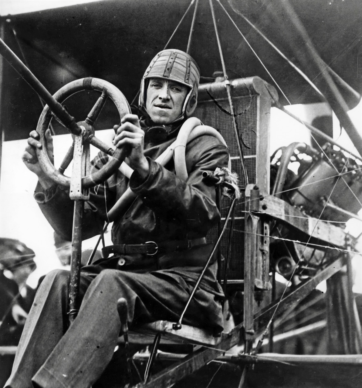 Seated in his Curtiss pusher biplane, just before taking off from USS Pennsylvania (Armored Cruiser # 4) to return to land, 18 January 1911. Earlier in the day he landed on the ship's deck, the first time an airplane had landed on a warship. Note Ely's flying attire, including a leather helmet and rubber inner tubes worn around his shoulders as a life preserver.  Photograph from the Eugene B. Ely scrapbooks.