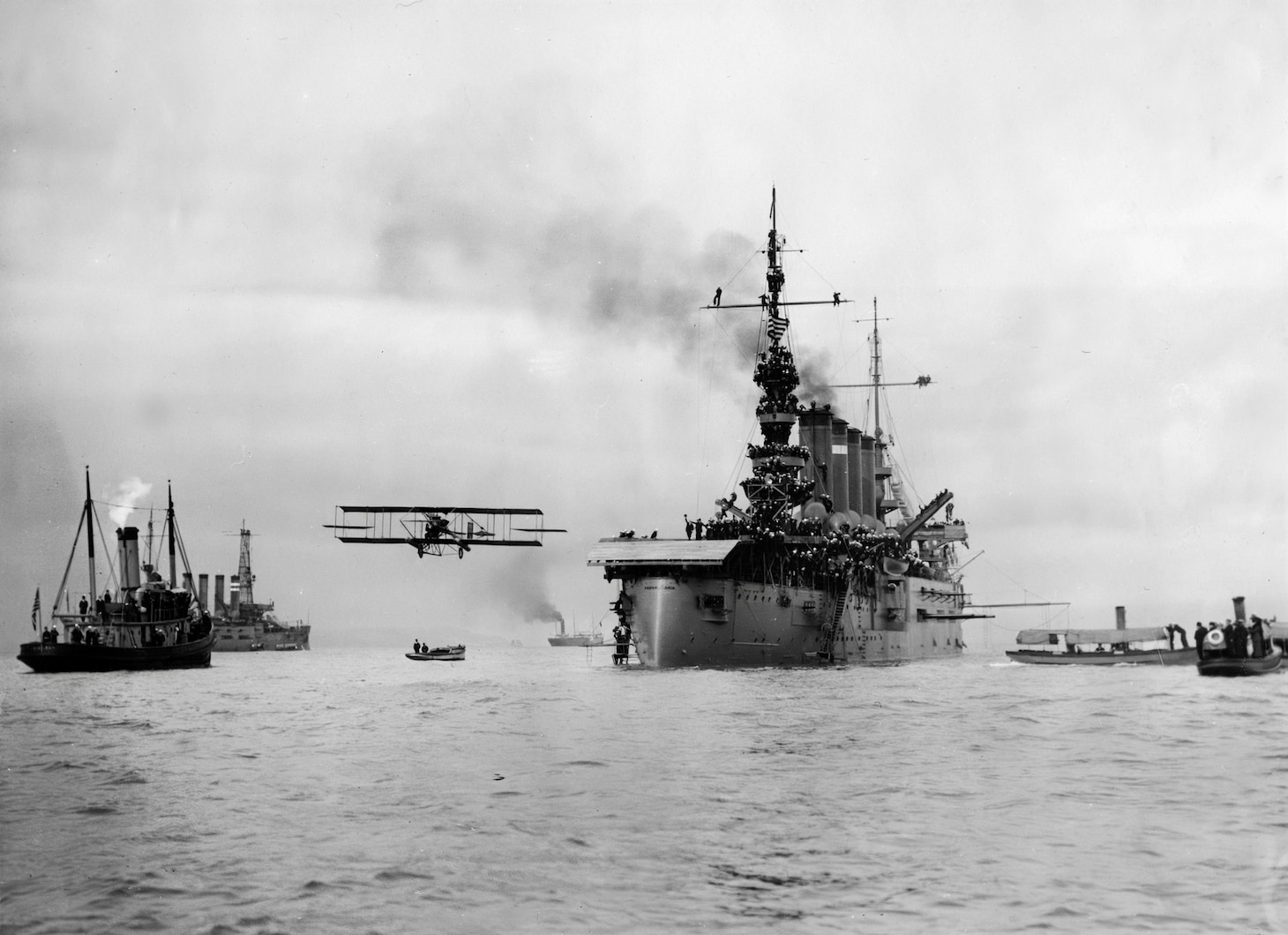 Eugene Ely’s plane taking off from the cruiser USS Pennsylvania (ACR 4) in 1911.  This is an accretion of 13 photographs related the S-005 Eugene Ely Collection. They were possibly compiled and donated by his wife Mabel in the 1930’s. The pages may have come from the original five scrapbooksthat were donated at an unknown date. These are photos of Ely’s first flight off the cruiser USS Birmingham (CL 2) in 1910, and his landing on USS Pennsylvania (ACR 4) in 1911. Some photos were assigned NH numbers (NH 1385, NH 77501, NH 77610, NH 82737) , see NH records for more extensive caption information. Photos may have been mounted out of sequence.