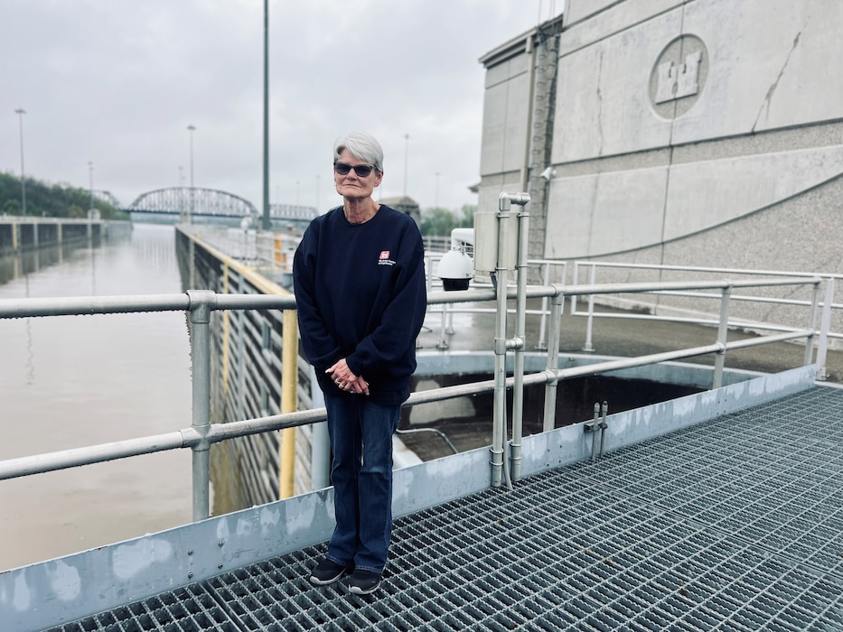 McAlpine Locks and Dam's first female  lock operator, Sally Waterbury, who has worked at McAlpine for nearly four decades, stands on the gates of the south chamber in front of the control tower April 10, 2024.