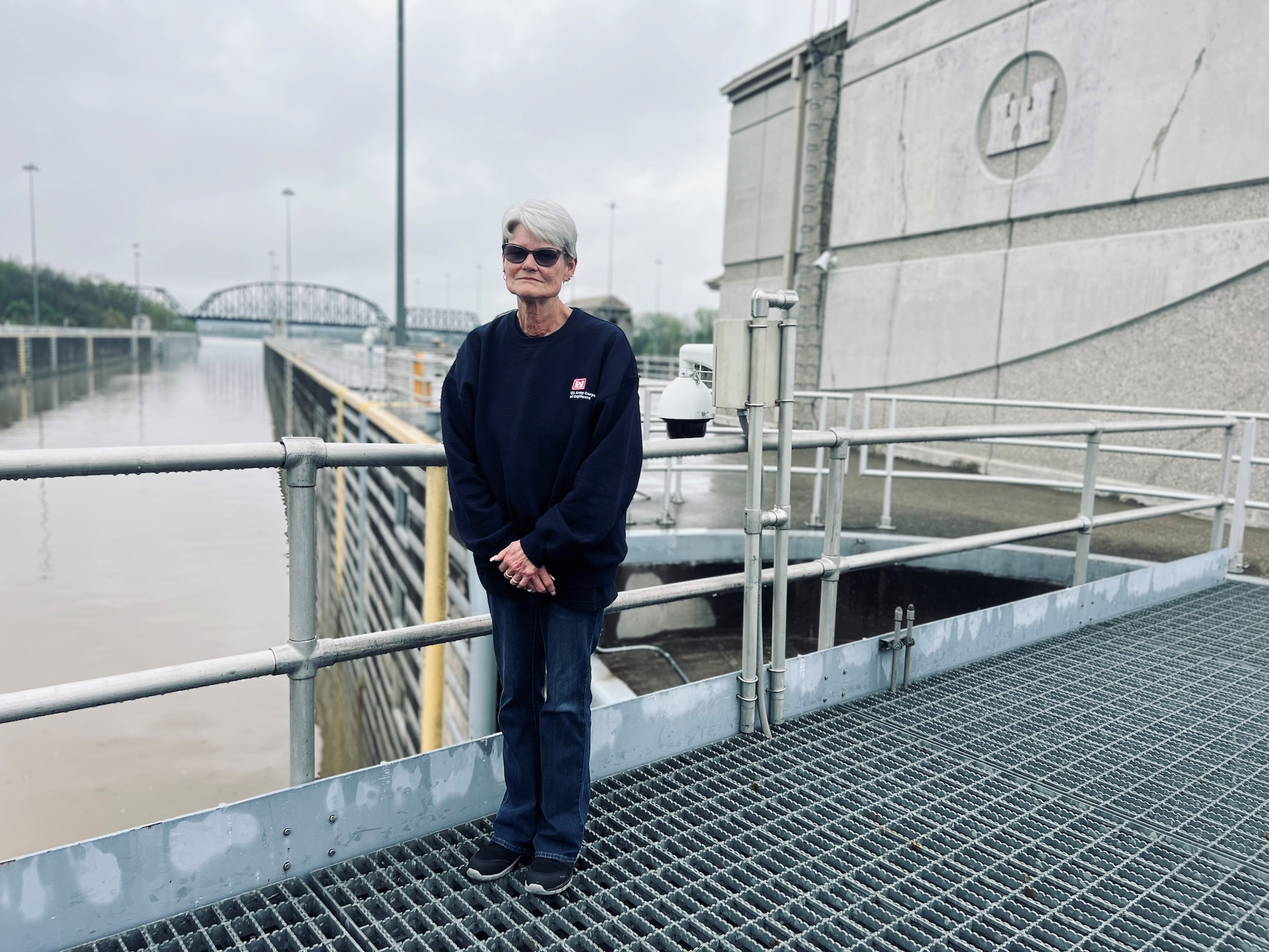 McAlpine Locks and Dam's first female  lock operator, Sally Waterbury, who has worked at McAlpine for nearly four decades, stands on the gates of the south chamber in front of the control tower April 10, 2024.