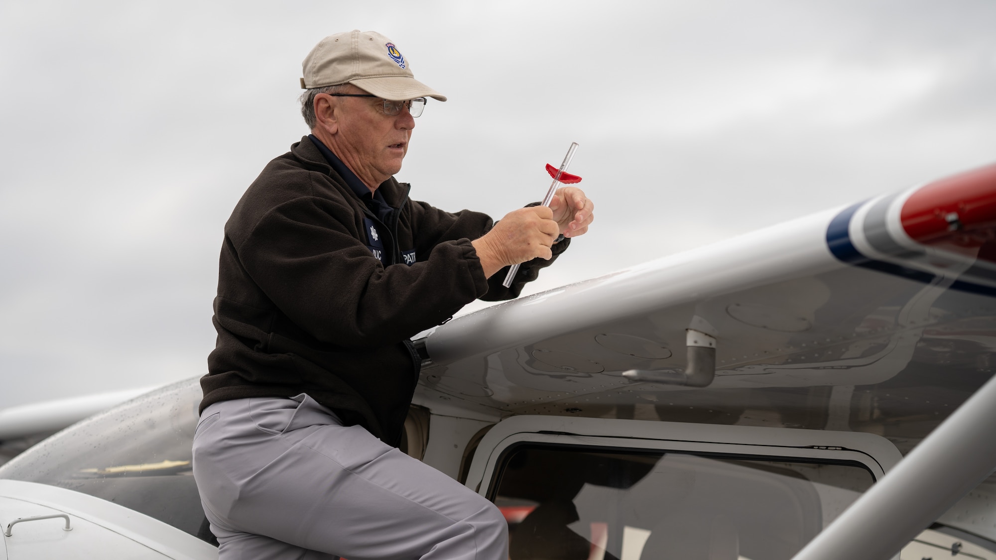 Civil Air Patrol pilot instructor demonstrates how to check the fuel of an aircraft.