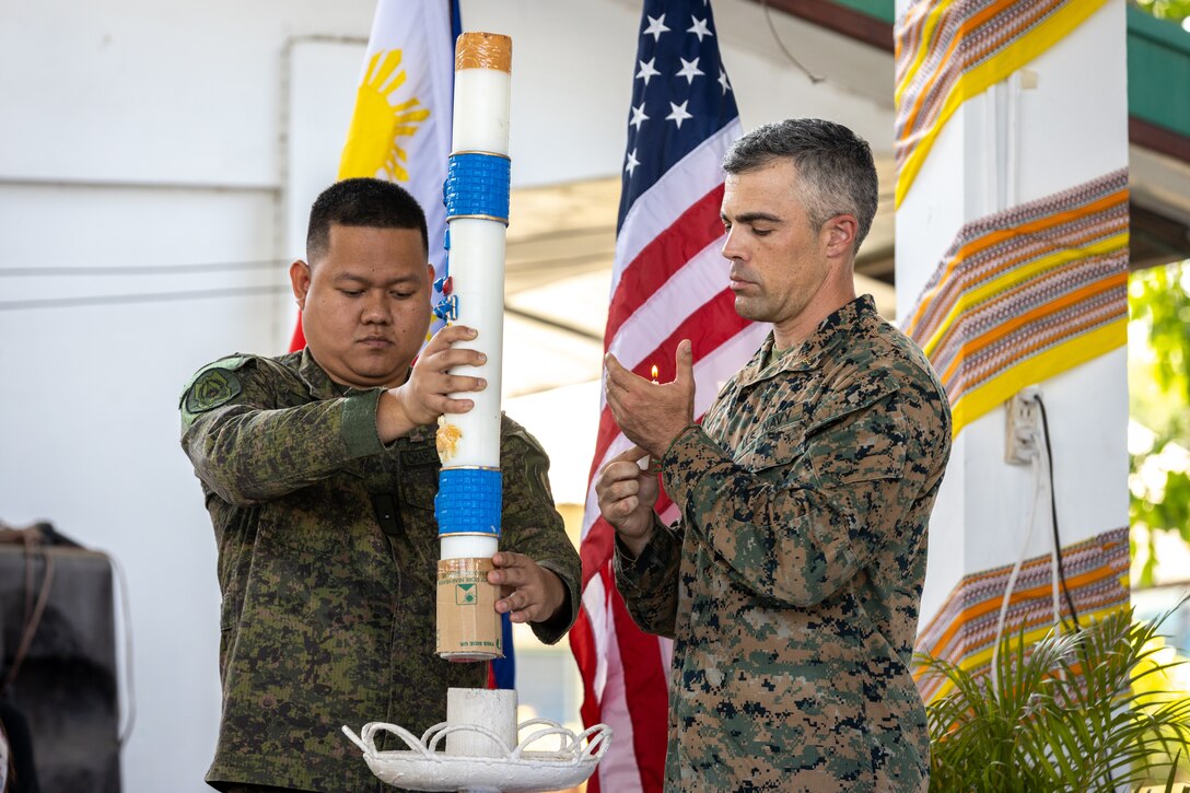 Philippine Army Probationary 2nd Lt. John Alfred Buyao and U.S. Navy Lt. Mark Weathers, both chaplains with the Combined Joint Civil-Military Operations Task Force, light a paschal candle as part of an interfaith ceremony during a ‘Bundles of Joy’ event held before Exercise Balikatan 24 at San Agustin Elementary School in San Fernando, La Union, Philippines, April 13, 2024. The ‘Bundle of Joy’ delivery consisted of televisions, laptops, printers, and school supplies to improve the learning environment for students, staff, and San Agustin Elementary School faculty. BK 24 is an annual exercise between the Armed Forces of the Philippines and the U.S. military designed to strengthen bilateral interoperability, capabilities, trust, and cooperation built over decades of shared experiences. (U.S. Marine Corps photo by Cpl. Trent A. Henry)