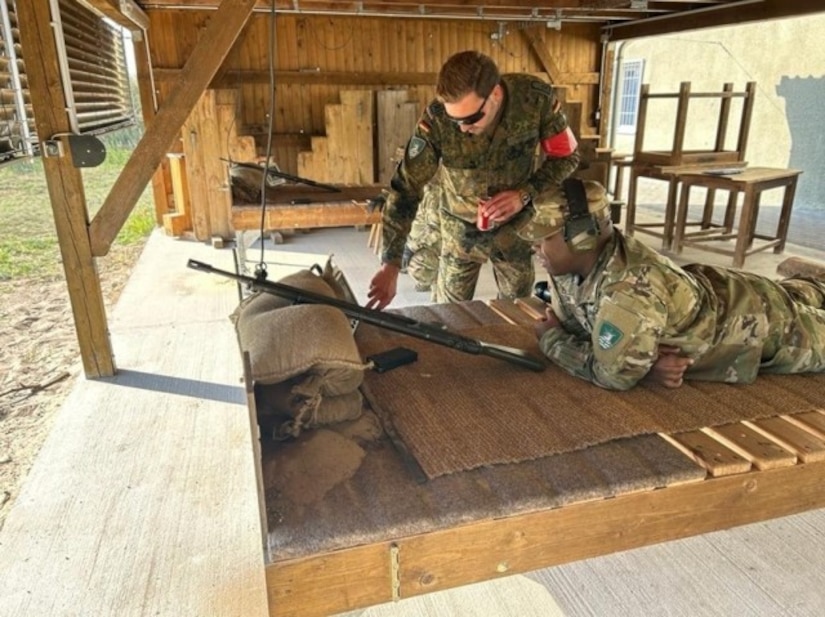 A solider shows another soldier part of a gun.