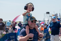 A kid and a dad smile for a photo.
