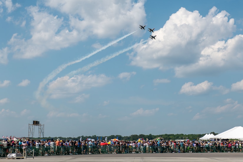 Planes fly over a crowd.