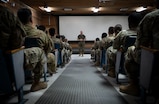 A photo of a service member talking to a crowd.