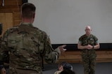 A photo of a service member standing up and asking a question.