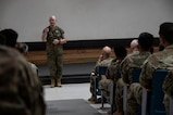 A photo of a service member talking to a crowd.