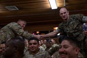 A photo of two service members shaking hands.