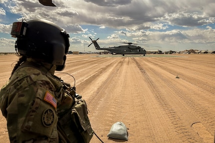 Alaska Army National Guard Staff Sgt. Sara Becker, a UH-60L Black Hawk helicopter crew chief assigned to 207th Aviation Troop Command, scans the area while waiting for passengers during the Weapons and Tactics Instructor Course 2-24 at a forward arming and refueling point near Marine Corps Air Station Yuma, Ariz., April 8, 2024.