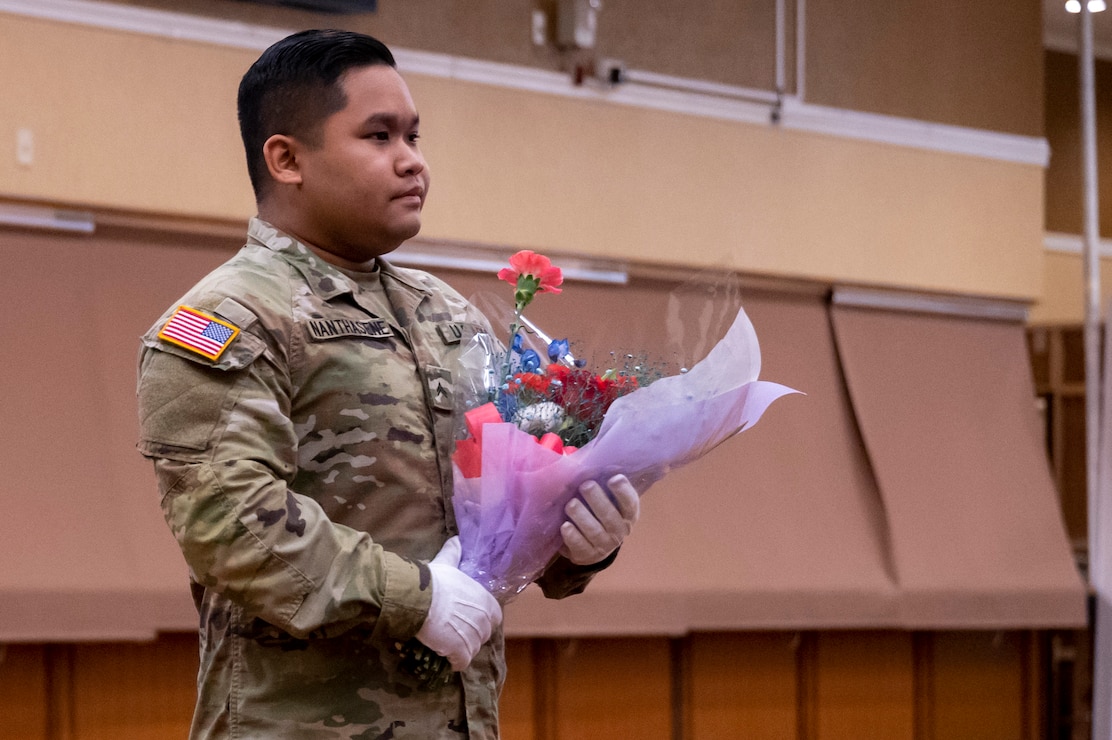 U.S. Army Cpl. Anthony Nanthasene, 22nd Space Company Soldier, stands with flowers to present to the family of the departing commander at Misawa Air Base, Japan, April 12, 2024.