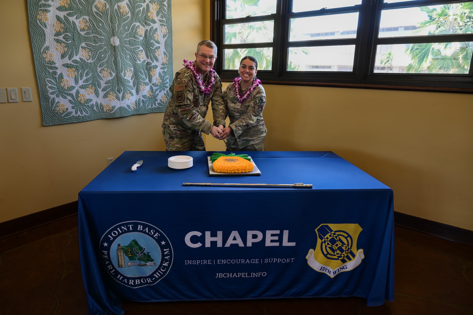Maj. Gen. Randall Kitchens, U.S Air Force Chief of Chaplains, and Senior Airman Maribel Rios-Stewart, 647th Air Base Group religious affairs journeyman, cut a cake together during a 75th Chaplain Corp Anniversary celebration at Joint Base Pearl Harbor-Hickam, Hawaii, April 23, 2024. It’s an Air Force tradition for the lowest and highest ranking Airman to cut the cake together. Kitchens later passed a slice of cake to Rios-Stewart to symbolize the passing of knowledge to a younger generation. (U.S. Air Force photo by Staff Sgt. Alan Ricker)
