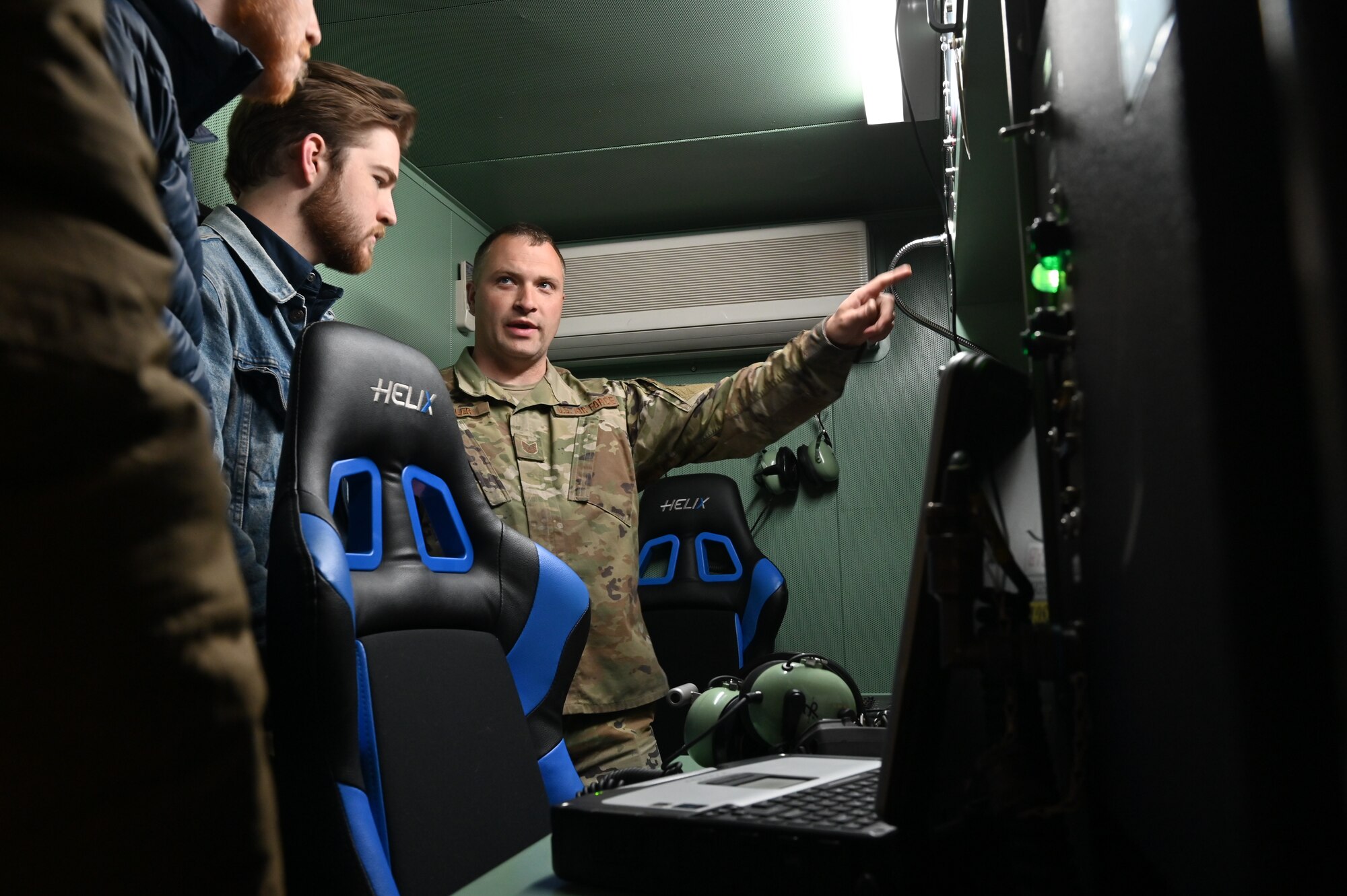 Airman pointing while two people listen