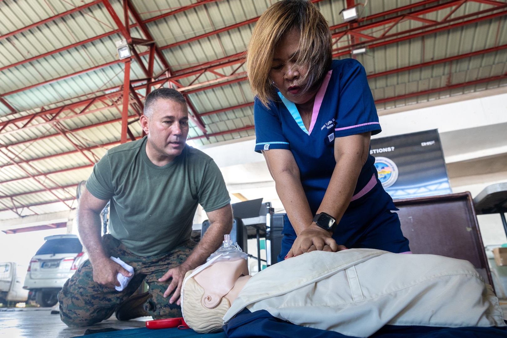 U.S. Navy Petty Officer 1st Class Ron Williams, a corpsman with the Combined Joint Civil-Military Operations Task Force, guides a local healthcare worker during a cardiopulmonary resuscitation practical application as part of a community health engagement held before Exercise Balikatan 24 at Davila Elementary School in Pasuquin, Ilocos Norte, Philippines, April 21, 2024. The Philippine and U.S. service members trained Ilocos Norte healthcare workers and residents on basic lifesaving skills such as cardiopulmonary resuscitation and tactical combat casualty care, increasing emergency care access and awareness. BK 24 is an annual exercise between the Armed Forces of the Philippines and the U.S. military designed to strengthen bilateral interoperability, capabilities, trust, and cooperation built over decades of shared experiences. (U.S. Marine Corps photo by Cpl. Trent A. Henry)