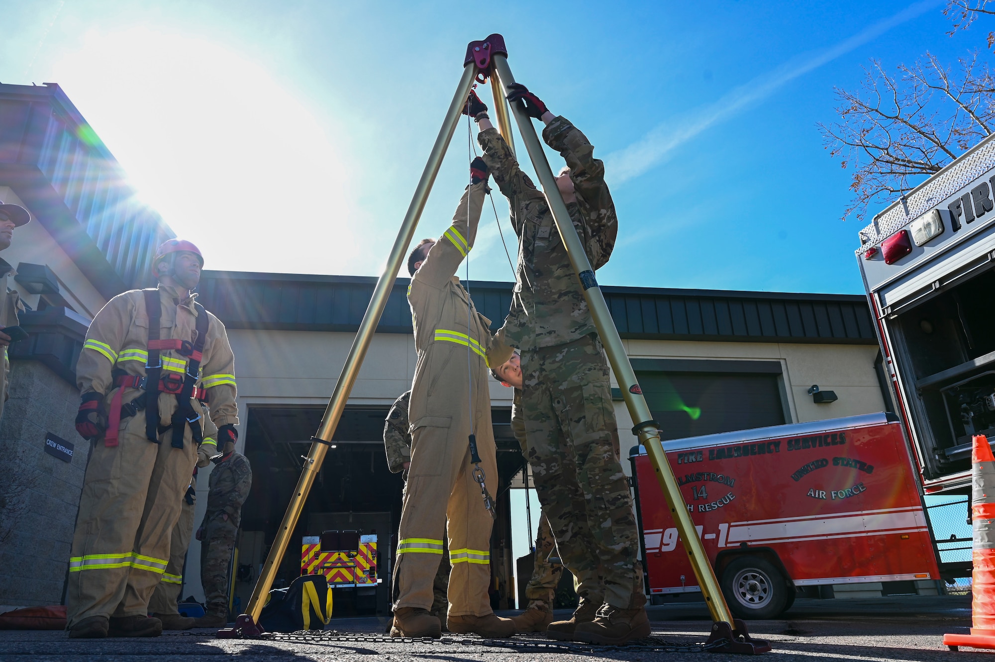 Firefighters set up a tripod for hoisting