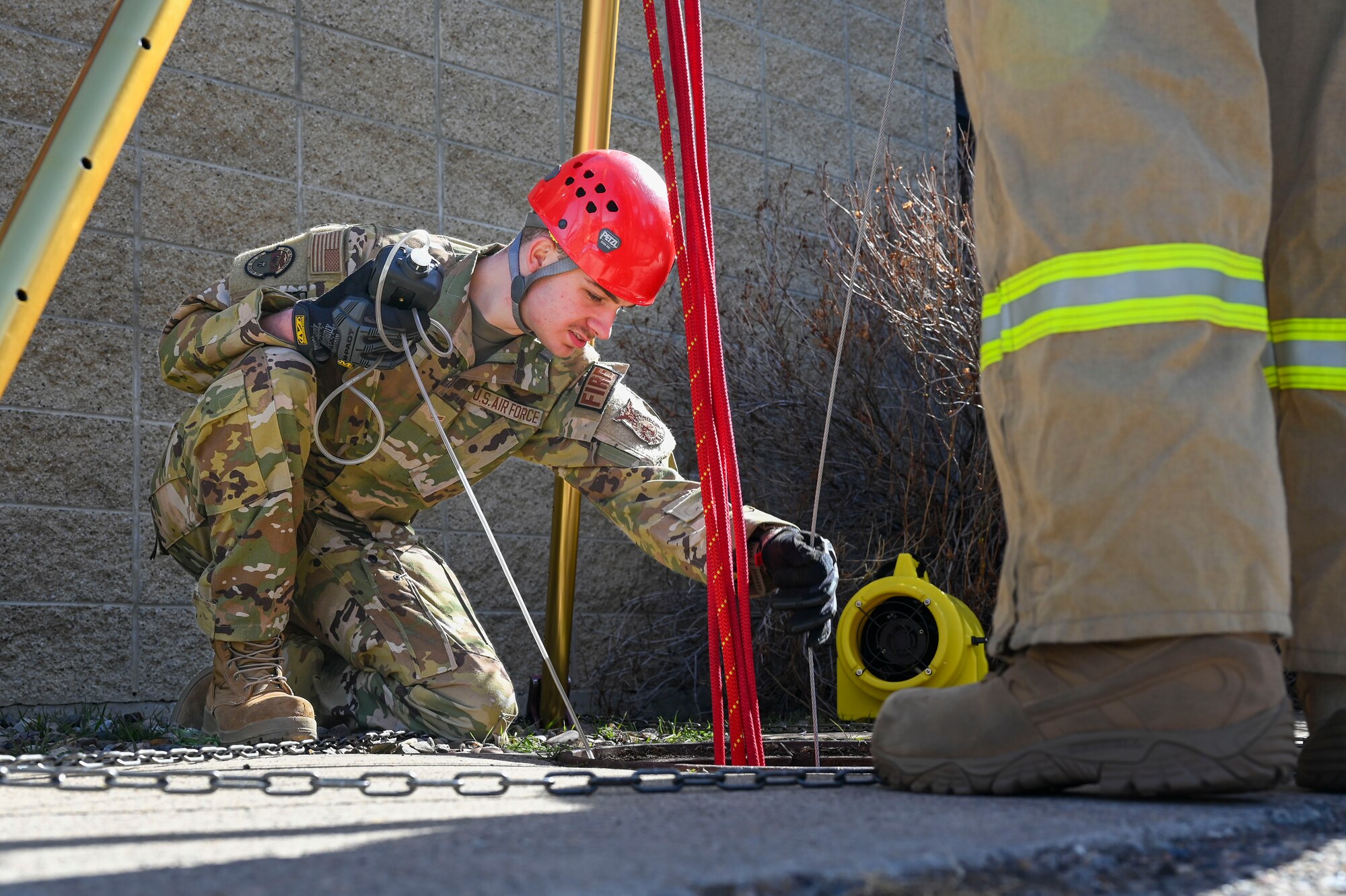 A person snakes a tube in a manhole