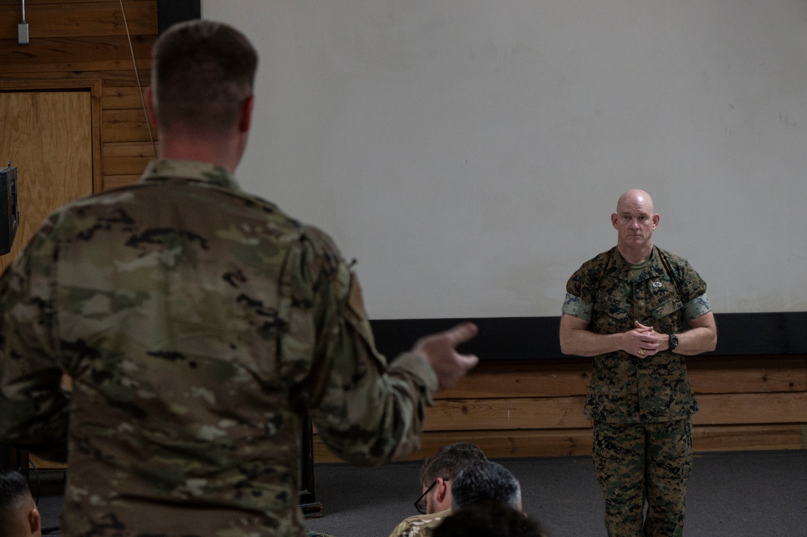 A photo of a service member standing up and asking a question.