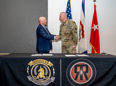 Maj. Gen. Bill Crane, Adjutant General of the West Virginia National Guard, signs a Memorandum of Understanding with Dr. Dennis Walters, Director of the Irregular Warfare Center, during a Ridge Runner Irregular Warfare program ceremony at Camp Dawson, Kinwgood, West Virginia, April 19, 2024. The IWC advances Department of Defense irregular warfare concepts, doctrine, and education, in collaboration with U.S. Joint Forces, key Allies and Partner Nations. The memorandum of understanding helps formalize the WVNG/IWC relationship, including enhancing opportunities for joint training exercises such as Ridge Runner and Ridge Healer programs, and additional sponsored events. (U.S. Army National Guard photo by Edwin L. Wriston)