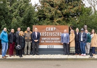 The Logistics Readiness Center Poland team poses for a photo in front of the entry sign at Camp Kościuszko in Poznan, Poland, where LRC Poland is headquartered. LRC Poland is the newest of eight LRCs under the mission command of the 405th Army Field Support Brigade. (U.S. Army courtesy photo)