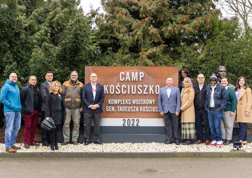 The Logistics Readiness Center Poland team poses for a photo in front of the entry sign at Camp Kościuszko in Poznan, Poland, where LRC Poland is headquartered. LRC Poland is the newest of eight LRCs under the mission command of the 405th Army Field Support Brigade. (U.S. Army courtesy photo)