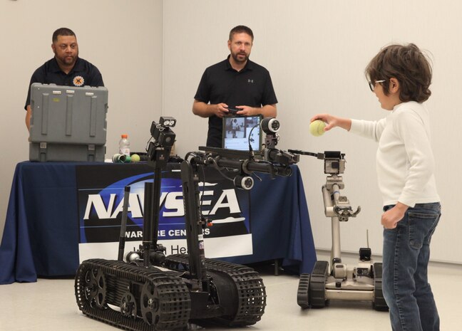 A young attendee of the College of Southern Maryland's (CSM) Art of Innovation Science, Technology, Engineering, Arts and Mathematics Festival interacts with explosive ordnance disposal robots, April 20, at CSM’s Velocity Center in Indian Head, Maryland.