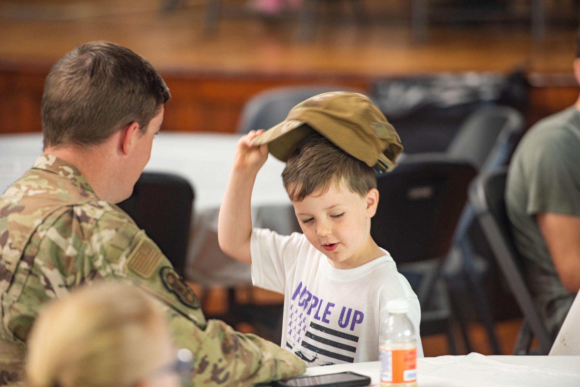 Kid takes his dads ocp cap off his head