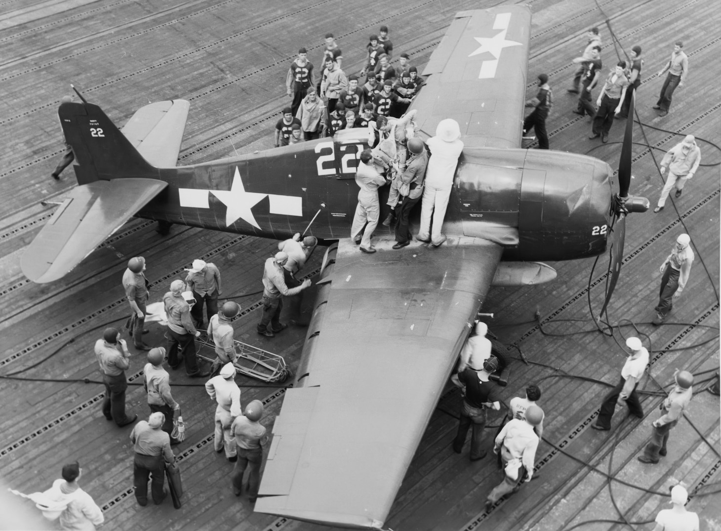 Battle of Leyte Gulf, October 1944. Removing a wounded pilot, Ensign A.A. Brauer, USNR, from his F6F after a strike on the Japanese fleet on 25 October 1944. Photographed aboard USS LEXINGTON (CV-16). The plane appears to have hit the crash barrier.