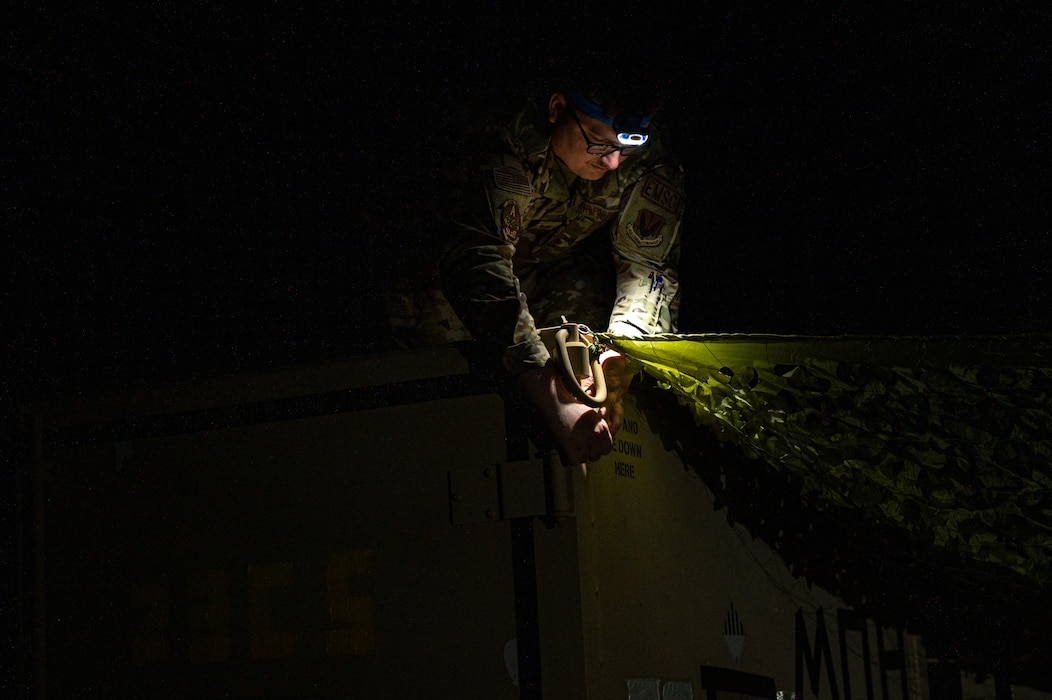 U.S. Airmen assigned to the 23rd Communications Squadron set up a tactical camouflage netting during Exercise Ready Tiger 24-1 at Savannah Air National Guard Base, Georgia, April 14, 2024. Airmen responded to an exercise scenario that required communications to be recalibrated at night. Built upon Air Combat Command's directive to assert air power in contested environments, Exercise Ready Tiger 24-1 aims to test and enhance the 23rd Wing’s proficiency in executing Lead Wing and Expeditionary Air Base concepts through Agile Combat Employment and command and control operations. (U.S. Air Force photo by Senior Airman Courtney Sebastianelli)